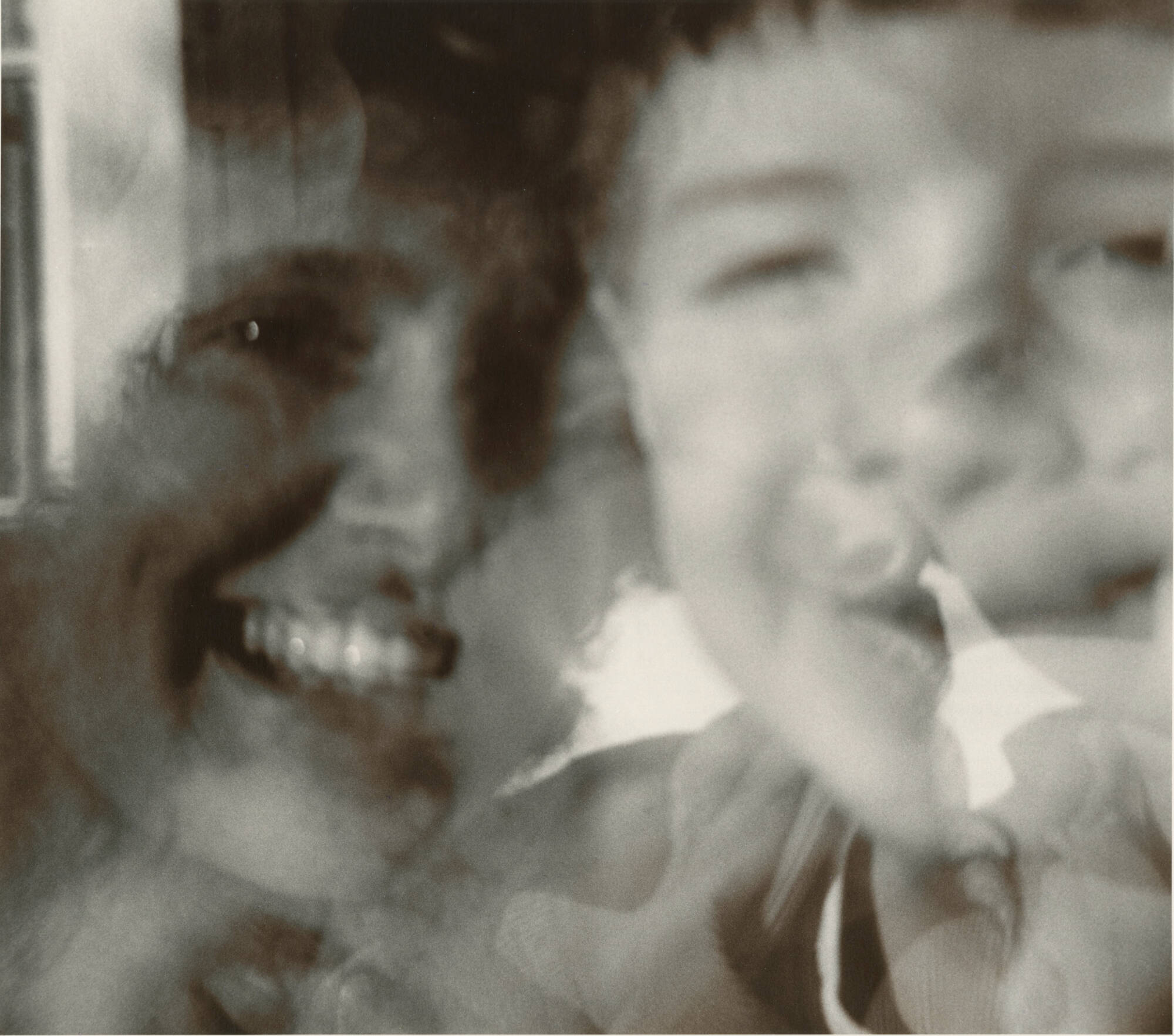 Black and white photograph of a woman and a young child, a closeup of their faces touching.